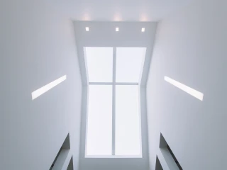 Plafond blanc avec de grandes fenêtres et des lumières intégrées. L’espace est minimaliste et épuré.