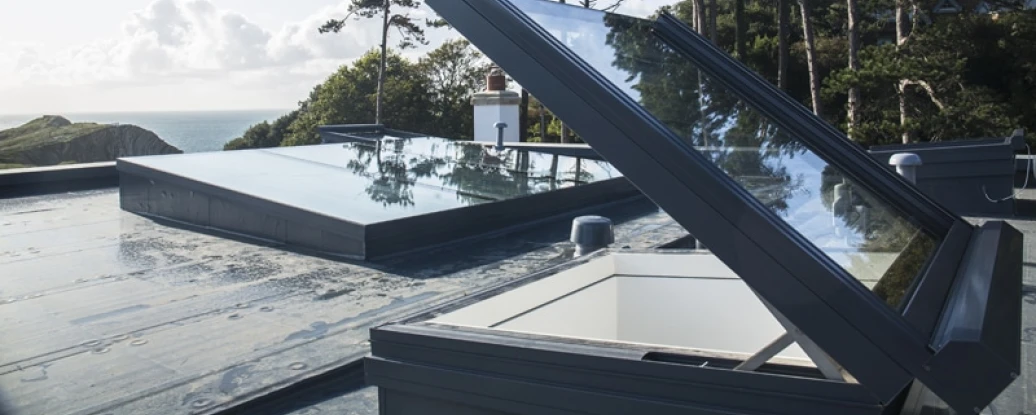 Open skylights on roof looking out on too grassy hills and ocean