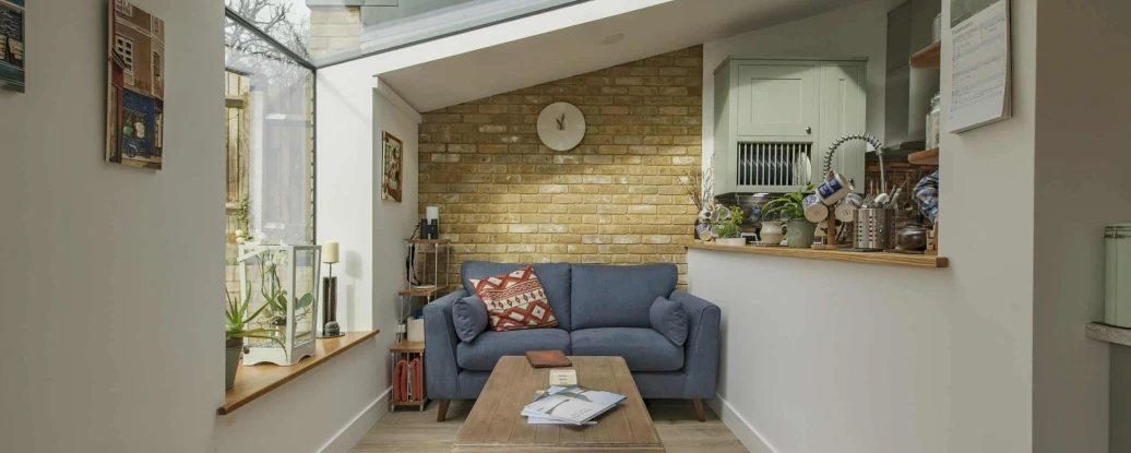 Shows a cosy room with a sofa next to a skylight