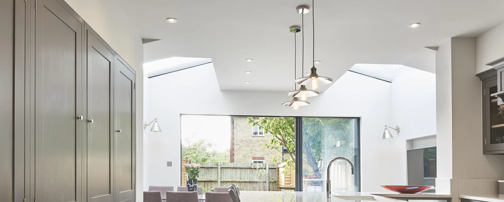 looking into a kitchen with skylights over the table with purple chairs