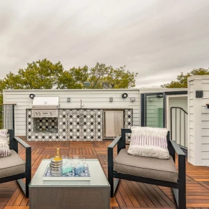 On wooden terrace showing two chairs facing you and then in the corner there is a skybox leading onto the terrace