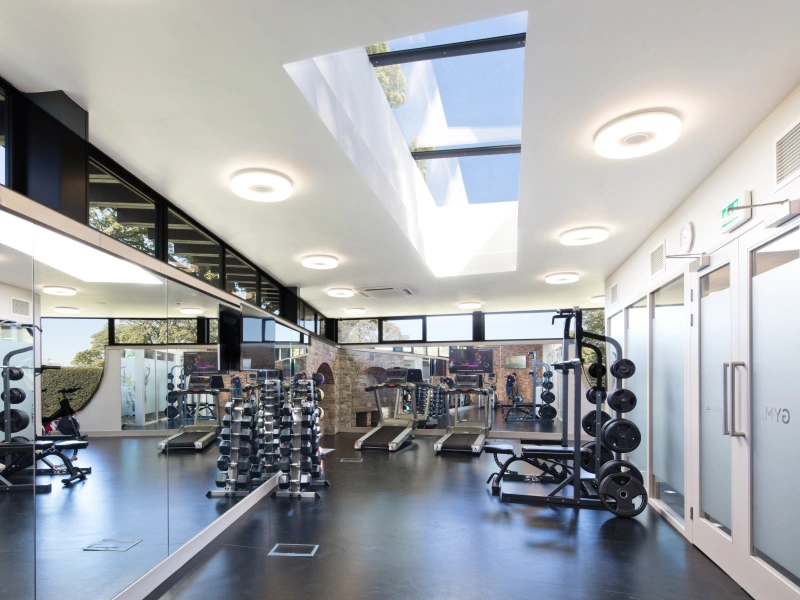 multi part skylight above gym equipment in white light gym